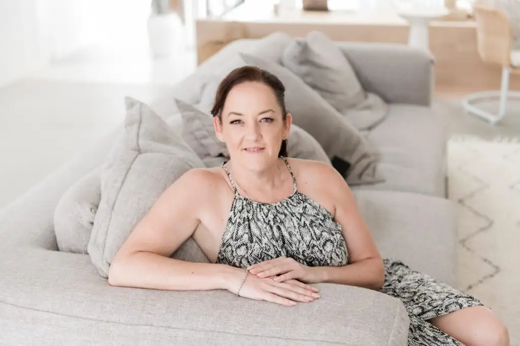 Kym Power seated on a couch, looking at the camera