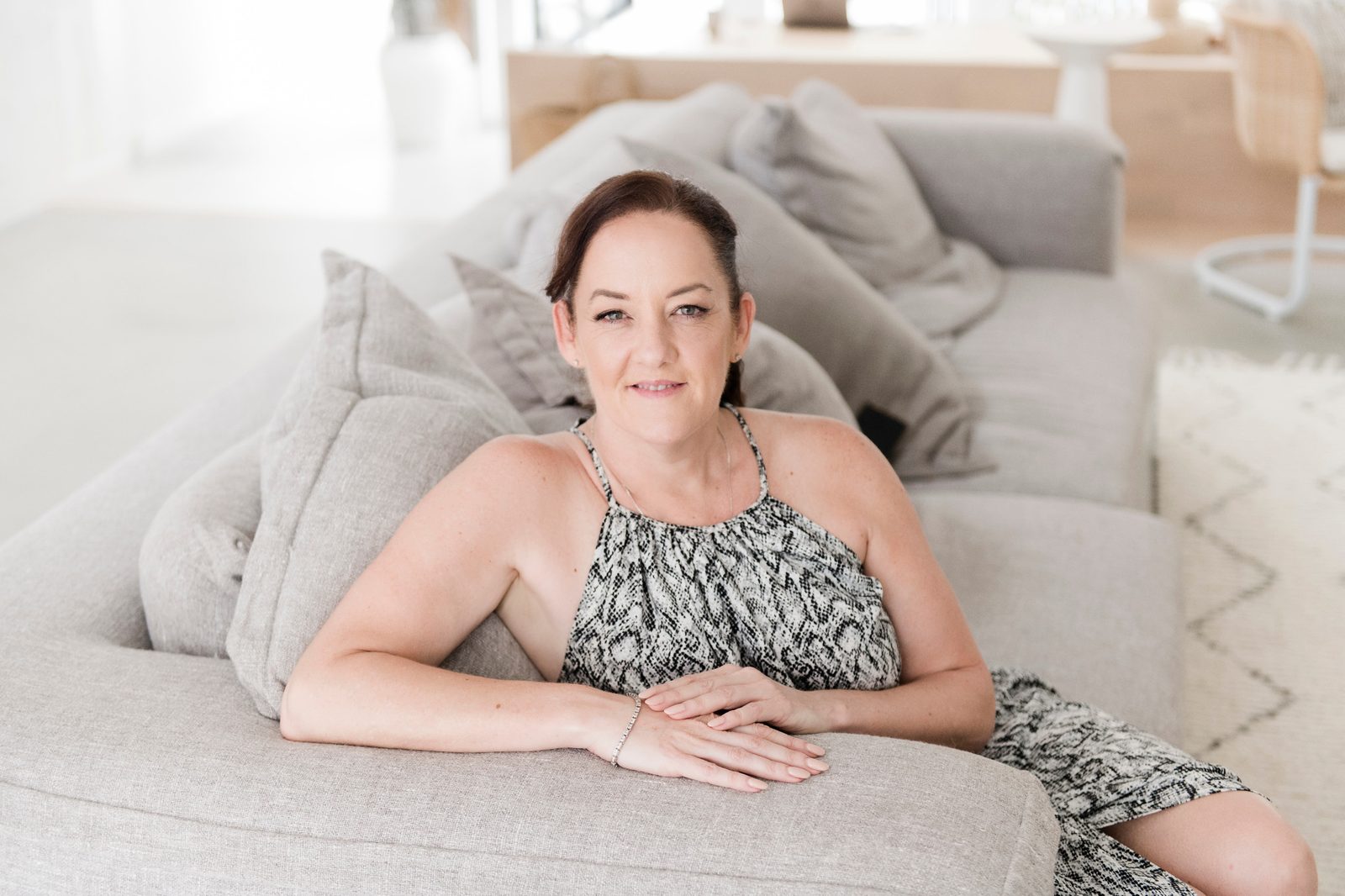 Kym Power seated on a couch, looking at the camera
